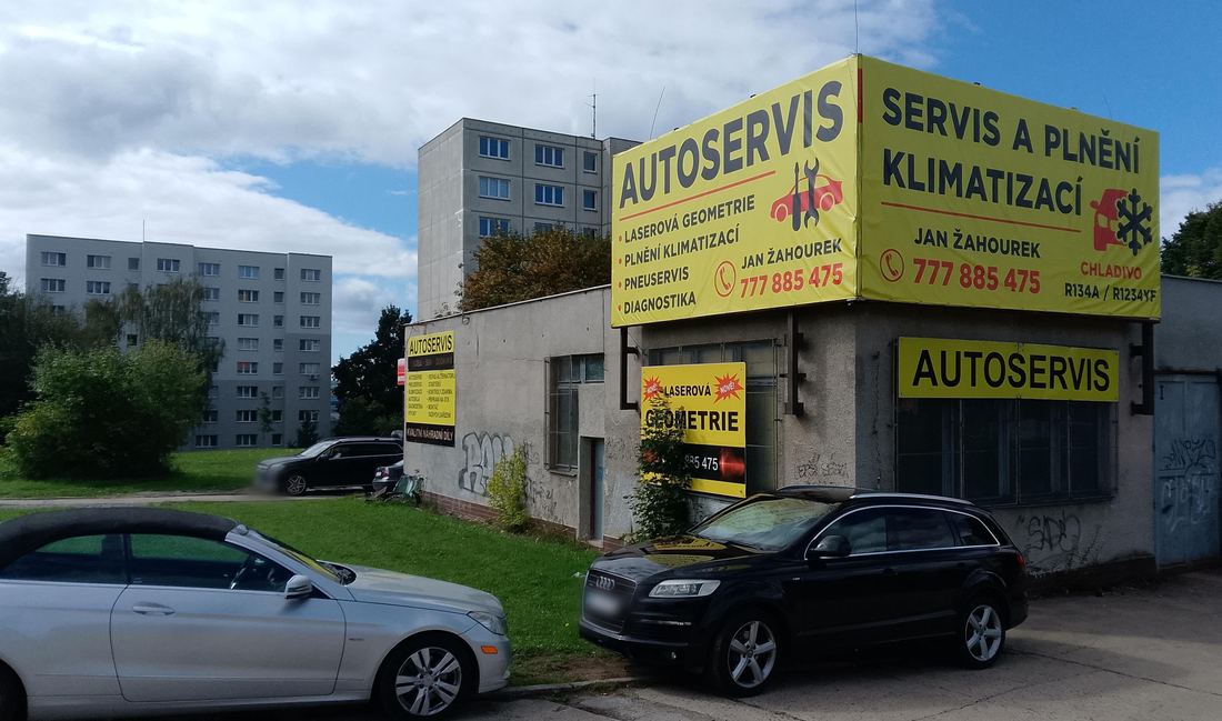 Budova autoservisu v Mariánské ulici v České Lípě se žlutými cedulemi Autoservis, Servis a plnění klimatizací, Jan Žahourek 777 885 475